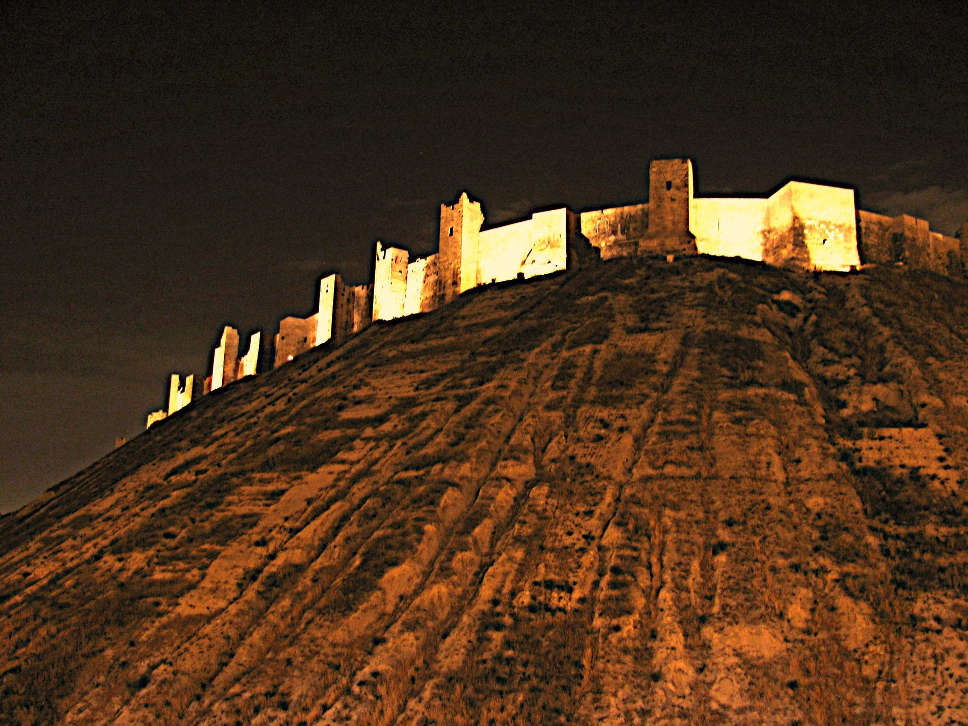 A large archaeological mound under a starry night sky